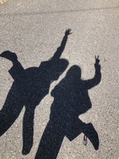 the shadow of two people standing in the street