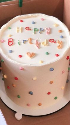 a birthday cake with white frosting and colorful sprinkles