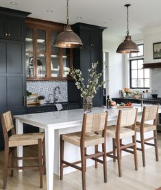 a kitchen island with four chairs around it