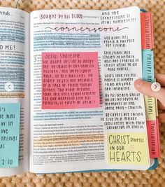 an open bible with sticky notes on the pages and words written in different languages,