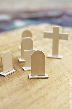 small wooden crosses are placed on top of a piece of wood