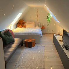 an attic bedroom with a bed, couch and television in the corner is lit up