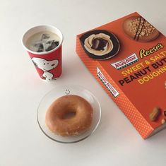 a box of peanut butter doughnuts next to a cup of coffee