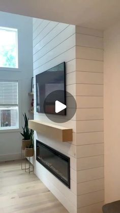 an empty living room with a flat screen tv mounted on the wall and wood flooring