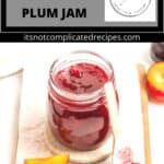 there is a jar of plum jam on the table