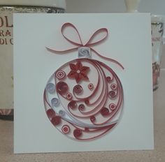 a white card with a red ornament on it