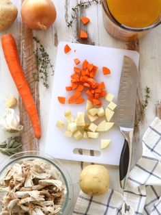 carrots, potatoes and onions on a cutting board next to a glass of juice