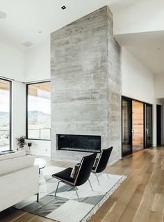 a modern living room with wood floors and large windows