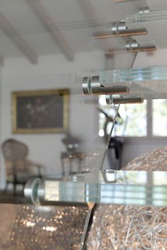 the reflection of a lamp and other items in a glass display case on a table