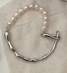 This elegant half bracelet features a sleek design crafted from high-quality sterling silver, adorned with a lustrous pearl. Perfect for adding a touch of modern sophistication and timeless elegance to any outfit, it offers a unique blend of simplicity and style. Modern Adjustable Pearl Bracelet, Elegant Sterling Silver Formal Bracelet, Formal Pearl Chain Bangle Bracelet, Minimalist Metal Pearl Bracelet, Modern Silver Pearl Bracelet With Oyster Design, Elegant Metal Pearl Bracelet As Gift, Modern Pearl Bracelet For Gift, Elegant Metal Pearl Bracelet For Gift, Modern Adjustable Pearl Jewelry