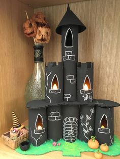 a castle made out of black paper with candles in the middle and decorations around it