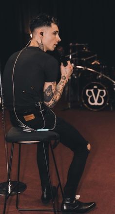 a man sitting on top of a chair next to a microphone