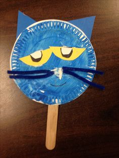 a paper plate with a blue cat face on it and a toothpick sticking out of it