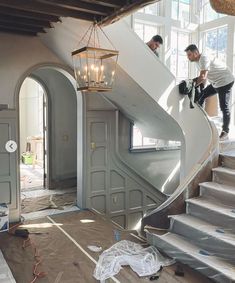 two men are working on an unfinished staircase