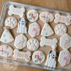 decorated cookies in the shape of dogs and puppies on a cookie sheet for a dog themed birthday party