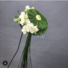 a bouquet of white flowers and greenery in a vase