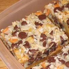 a plastic container filled with lots of different types of desserts on top of a wooden table