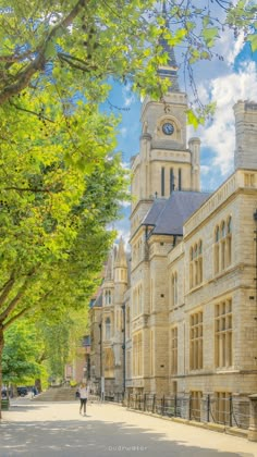 a large building with a clock tower on the side of it's face next to trees