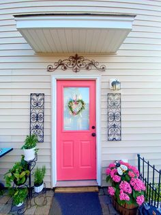 a pink door and some potted plants