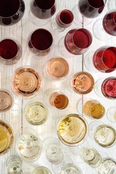 there are many glasses of wine on the table with each one in different colors and sizes