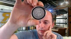 a man holding up a coin in front of his face