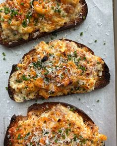 three pieces of bread topped with cheese and herbs