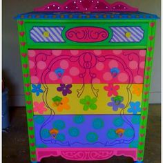 a multicolored dresser with flowers and butterflies painted on it