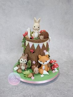 a cake decorated with woodland animals and flowers