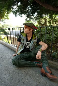 a man sitting on the ground wearing green striped pants