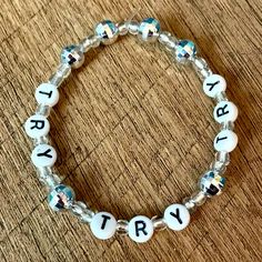 a beaded bracelet with the word try written on it, sitting on a wooden table