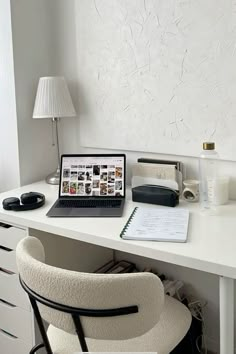 a laptop computer sitting on top of a white desk next to a chair and lamp