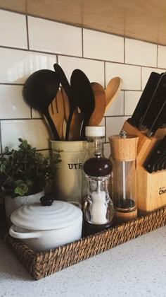 kitchen utensils and cooking utensils are arranged in a basket on the counter