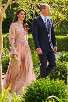 the couple are walking together in their formal attire