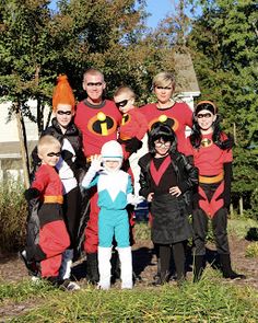 a group of people dressed in costumes posing for a photo outside with trees and bushes behind them