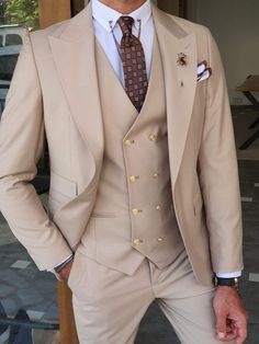 a man wearing a tan suit and tie