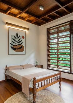 a bed sitting in a bedroom next to a window with shutters on both sides