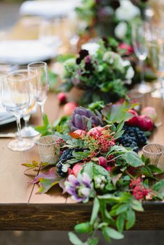 the table is set with flowers and wine glasses