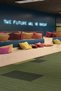 the future will be bright neon sign is on the wall next to couches and pillows