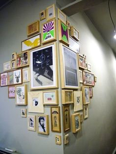 a wall with many framed pictures on it