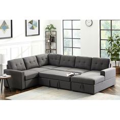 a living room with a gray sectional couch and coffee table in it, along with pictures on the wall