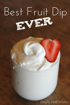 a close up of a cup with whipped cream and a strawberry on the top,