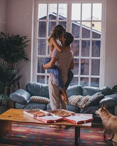 two people hugging each other in front of a window