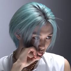 a woman with blue hair is posing for the camera