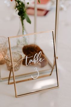 the table numbers are displayed in a glass box on top of a white table cloth