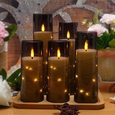 lighted candles are sitting on a wooden stand