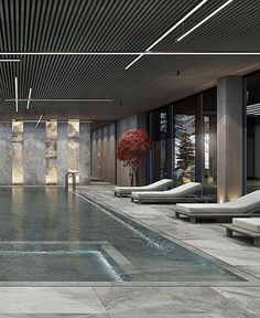 an indoor swimming pool surrounded by lounge chairs