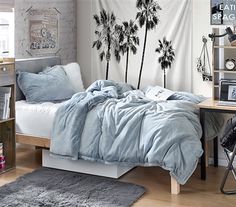 a bed room with a neatly made bed and palm trees on the wall