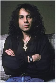 a man with long hair sitting on top of a couch