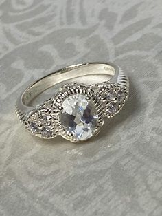 a white gold ring with an oval cut diamond in the center