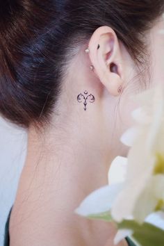 a close up of a person's ear with a flower behind it and the back of their ear